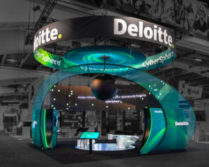 Deloitte's vibrant trade show booth featuring a spiral green structure, branded LED screens, and suspended circular sign